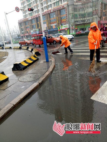 临沂冬季下雨积水 环卫工人忙清理保障路面畅通