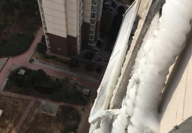 济南领秀城一居民楼外墙挂“冰刀” 冰挂坠下摔得粉碎