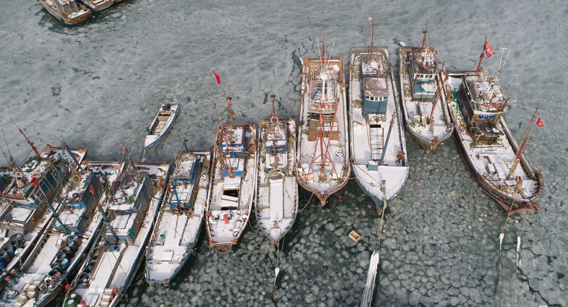 烟台持续低温天气 渔船码头遭海水冰封