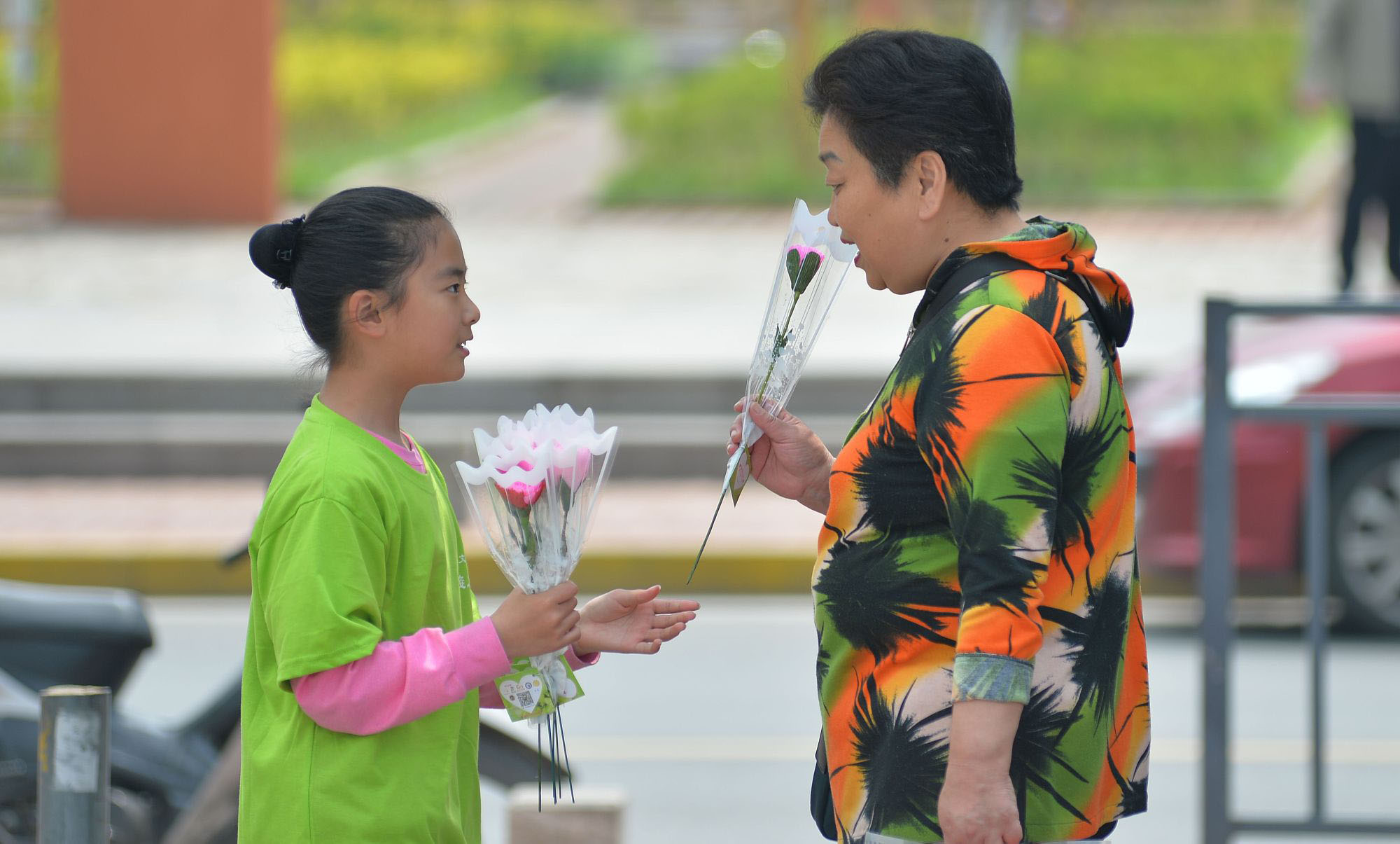 青岛：小学生制作康乃馨花朵 街头送给“妈妈们”