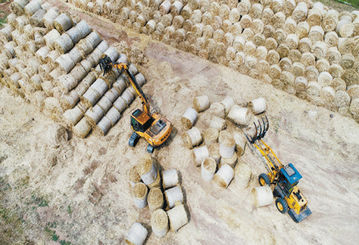 临沂：工人驾驶抓草机整理回收小麦秸秆