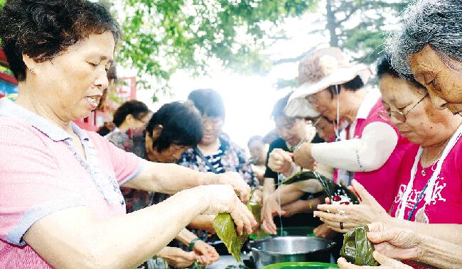 潍坊丹桂里小区60余名居民聚在一起包粽子迎端午
