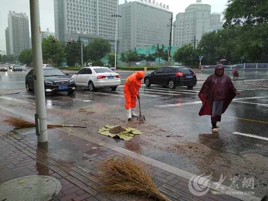 日照环卫工人雨中清淤为道路保畅