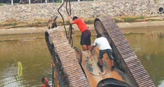 挖掘机作业时掉河 重型吊车“出手搭救”