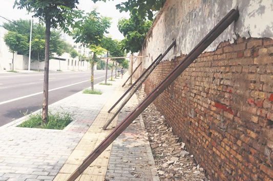 淄博高新区一路边墙体倾斜 木棒支撑有隐患