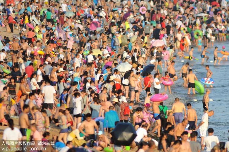 青岛34℃高温来袭 游客海滩密集扎堆避暑纳凉
