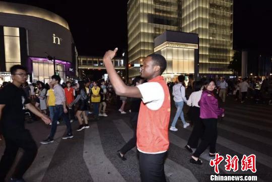 国庆假期的杭州街头:国际志愿者助疏导交通_大