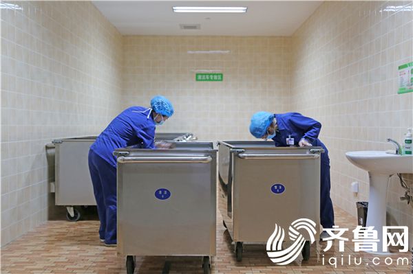 洗涤室员工为医用织物运输车辆清洁消毒
