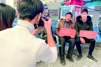 济南西站“春运照相馆”免费为旅客拍照，留下春运记忆