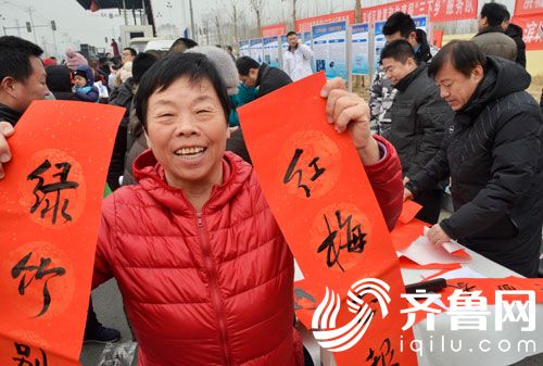1月30日，在滨城区“三下乡”活动现场，一群众展示书法爱好者给自己写的春联