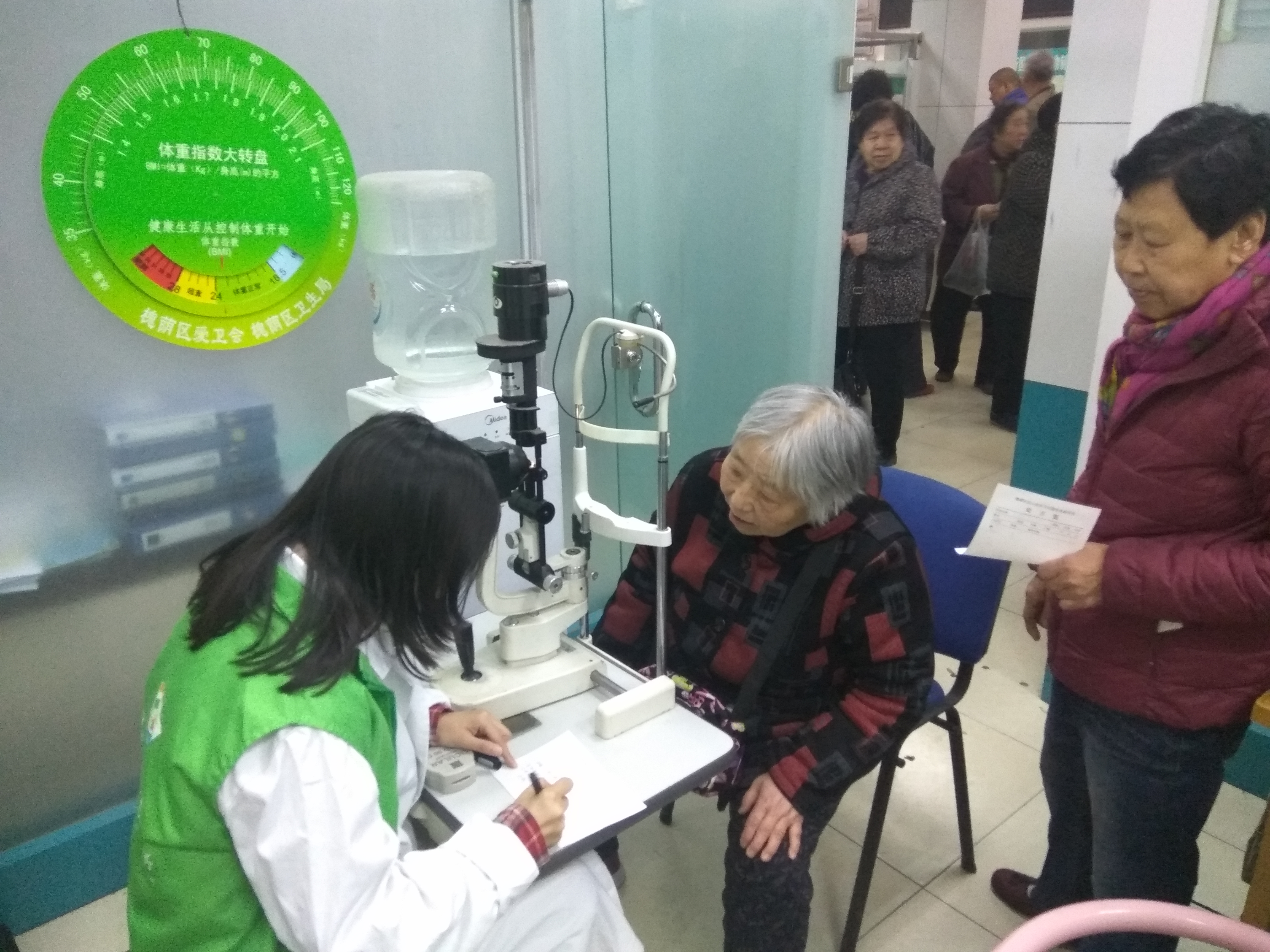 青年志愿者为社区老年人进行眼科检查
