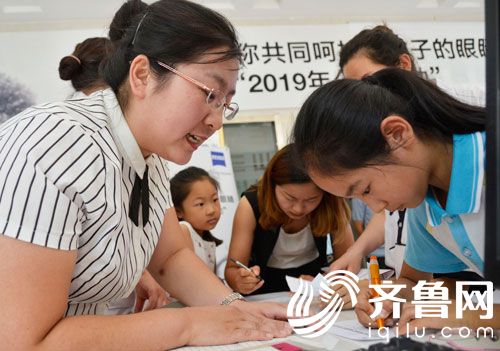 滨州姜玉坤眼视光中心工作人员在指导学生填写信息。1