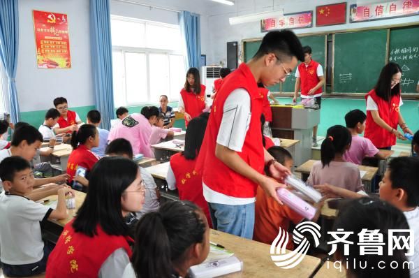 5、7月10日，大学生志愿者给农村娃发放学习用品。