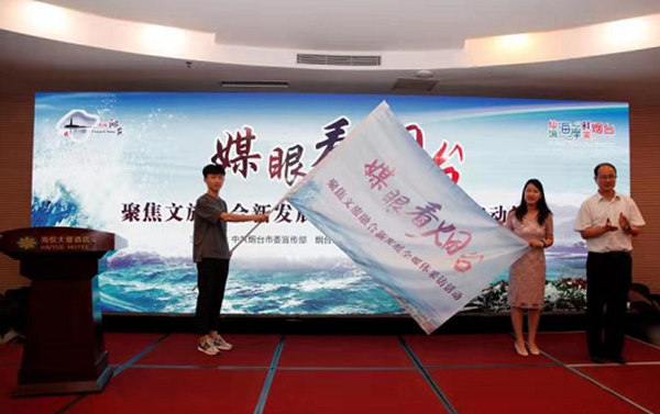烟台市委宣传部副部长李波向媒体代表授旗_副本