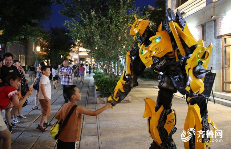 8月17日，在即墨古城内，一名小朋友与人扮机器人互动。(张进刚  摄)电话  13854260100.JPG
