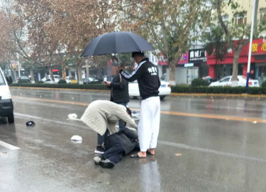 冠县：老人骑车被撞受伤 小伙雨中撑伞陪护