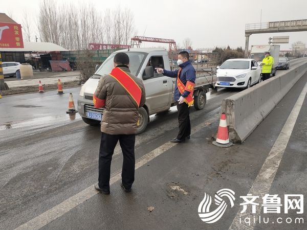 2月2日，志愿者姚军（中）在环鲁检查卡点参与交通劝阻