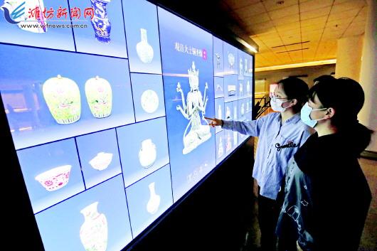 在潍坊市博物馆内,市民通过“多宝阁”了解馆藏文物的信息。摄影 张驰