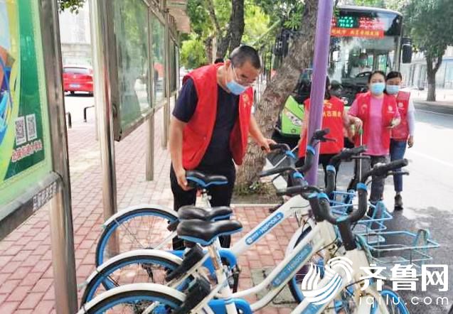 滨城区北镇街道志愿者在摆放共享单车，规范停放。