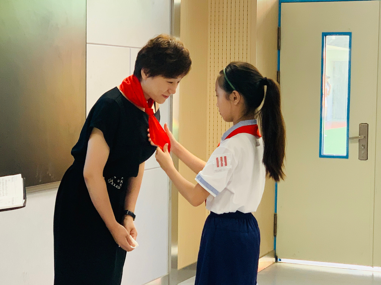 济南师范学校附属小学的学生代表为李林峻佩戴红领巾