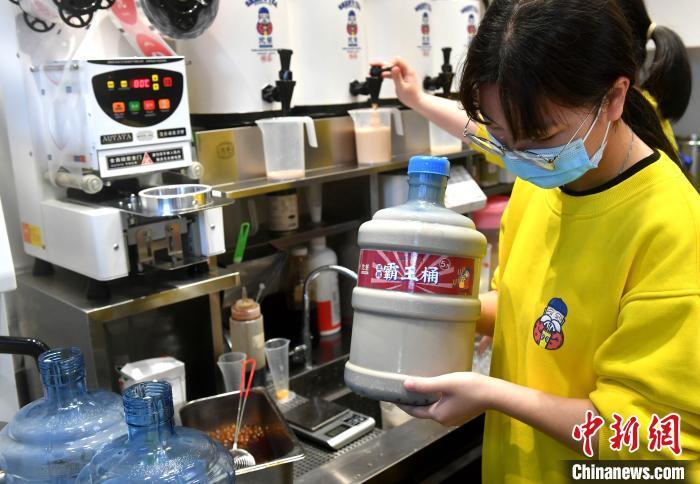 一奶茶店工作人员正在制作5升“霸王桶”奶茶。 吕明 摄