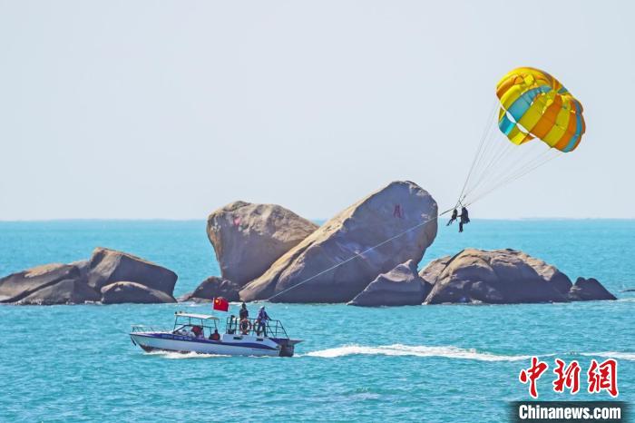 游客在天涯海角体验海上拖伞项目。　童承东 摄