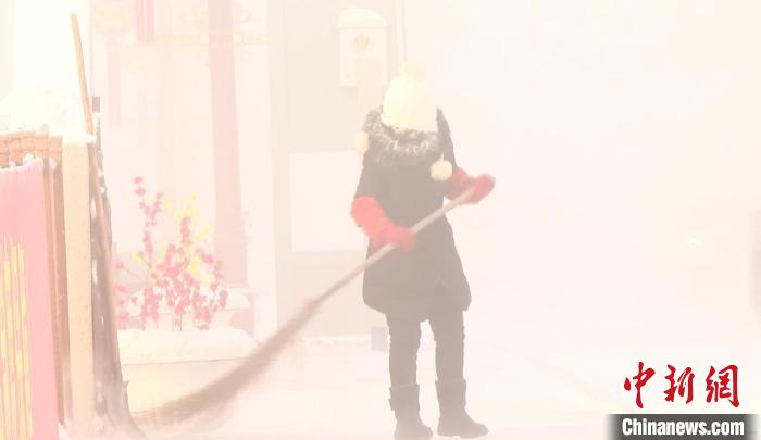 图为环卫工人冒着极寒天气清理着街道卫生。　根河市融媒体中心供图