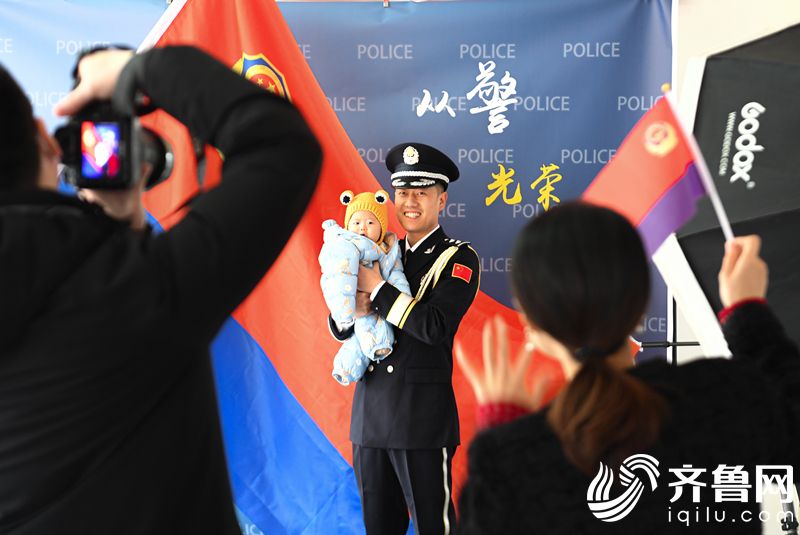 2022年1月7日，山东省东营市，一名民警与家人拍摄“从警光荣”纪念照。 (4)