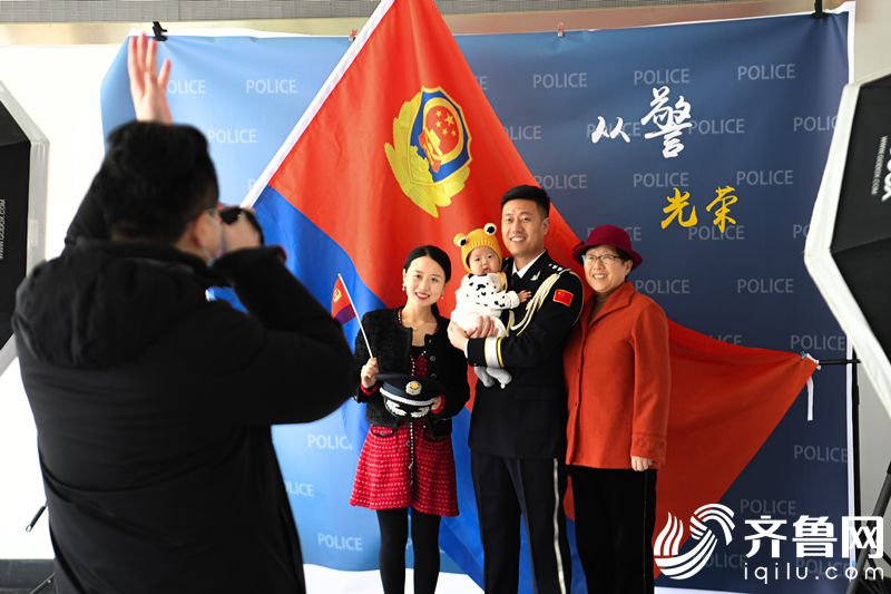 2022年1月7日，山东省东营市，一名民警与家人拍摄“从警光荣”纪念照。 (2)