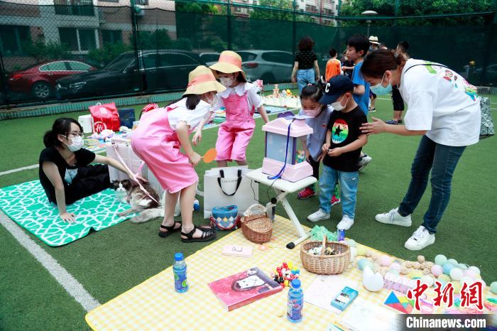 社区网球场变身“金童集市”吸引孩子前来欢度“六一”。　汤彦俊 摄