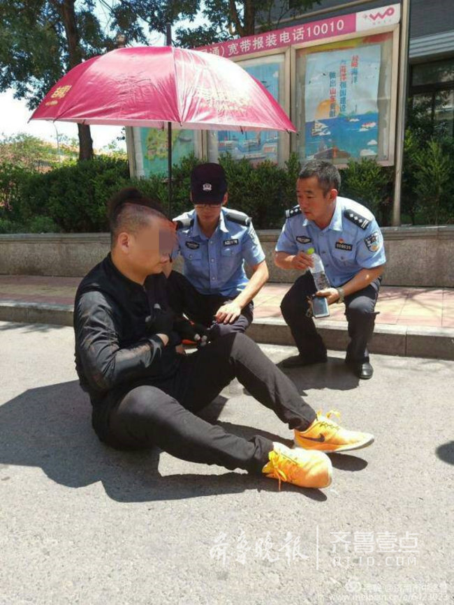 快遞小哥疑似中暑暈倒街頭，濟南民警撐傘幫其避暑