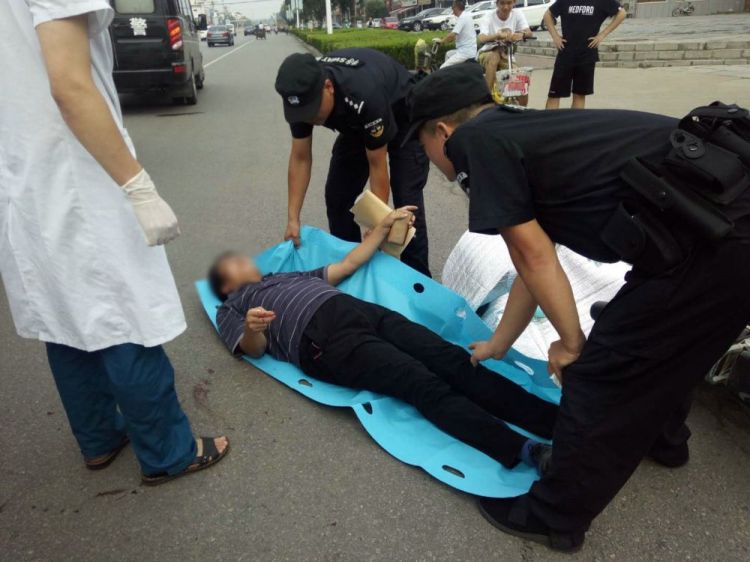 男子受伤倒地 曲阜特警为其撑伞等待120救援