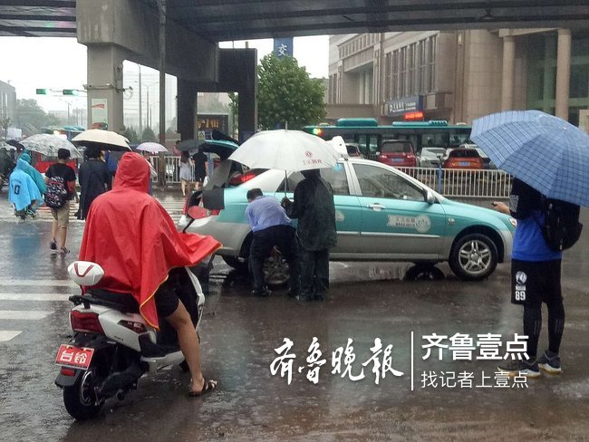 出租車司機雨中修車，濟南暖心父子路過幫忙撐傘