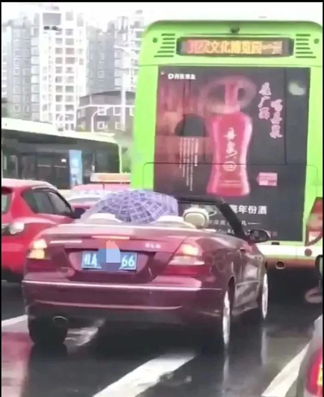 男子雨天打雨傘開敞篷跑車!網友:土豪的煩惱你不懂