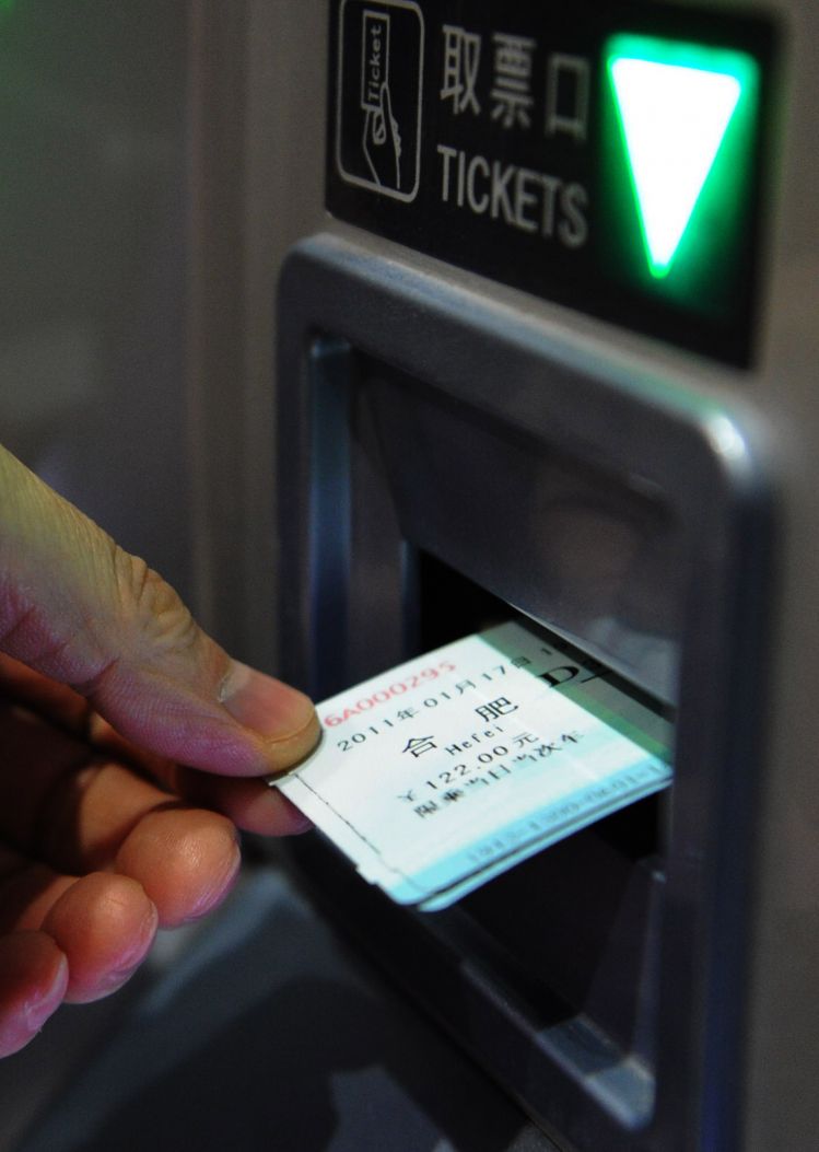 一名旅客在合肥火车站自动售票机上提取刚买到的火车票(2011年1月17