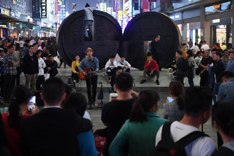 10月12日,長沙黃興路步行街持證上崗的街頭藝人在表演時吸引路人圍觀.