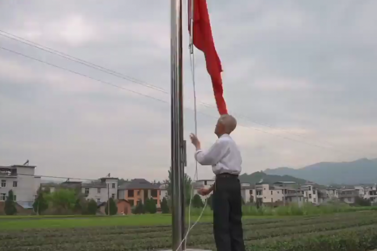 清晨，朱宗鶴將國旗升起。圖源：人民視頻截圖