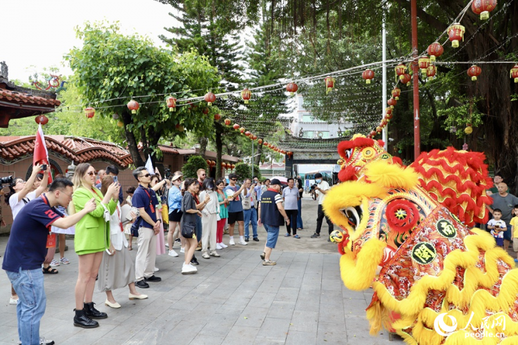 看到海澄城隍廟舞獅精彩表演，中外媒體采訪團(tuán)的成員們紛紛拿出手機(jī)拍照記錄。人民網(wǎng) 謝小姿攝